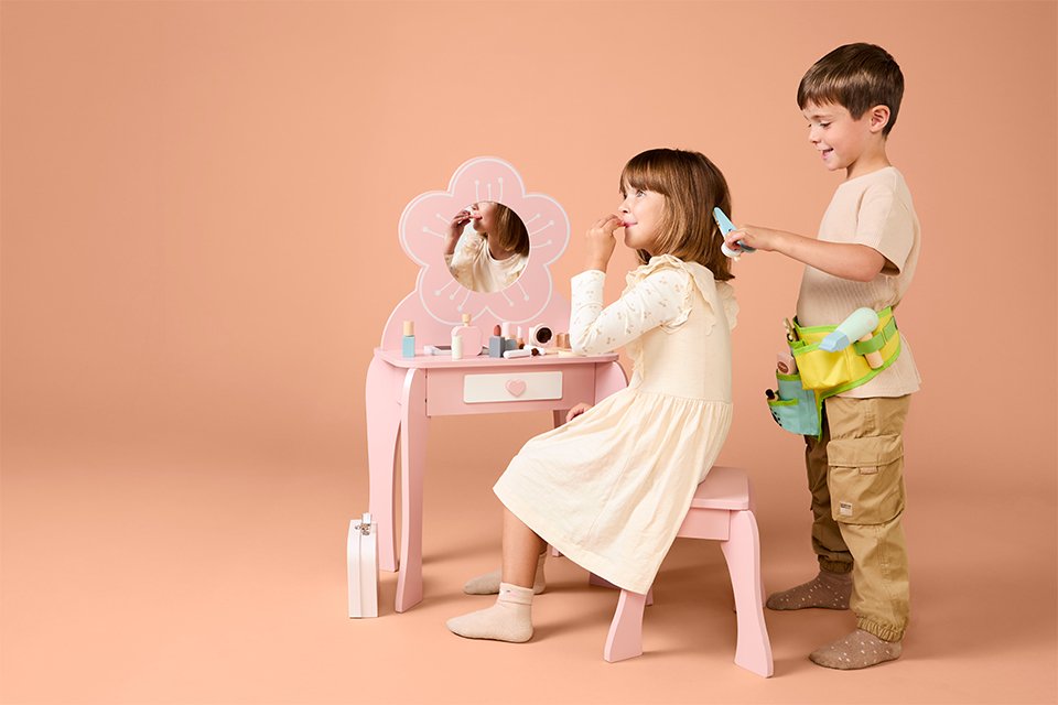 A boy brushing a girl's hair using Chad Valley's role play toy.